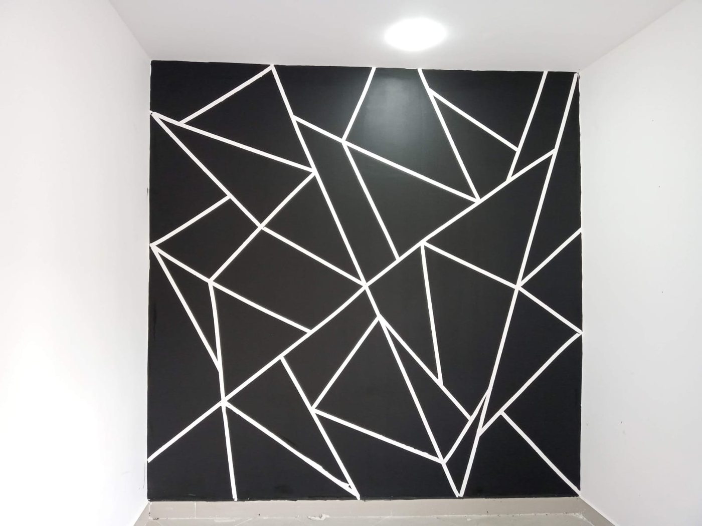 Muro pintado con diseño geométrico en negro y blanco