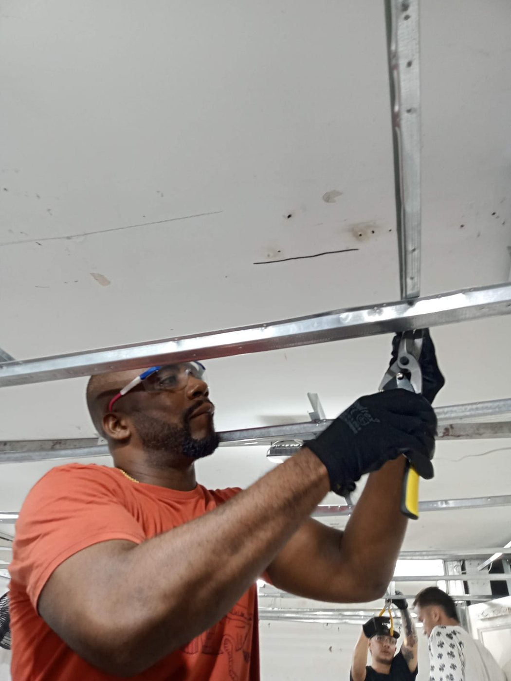 Maestro instalando perfilería de cielo raso en drywall